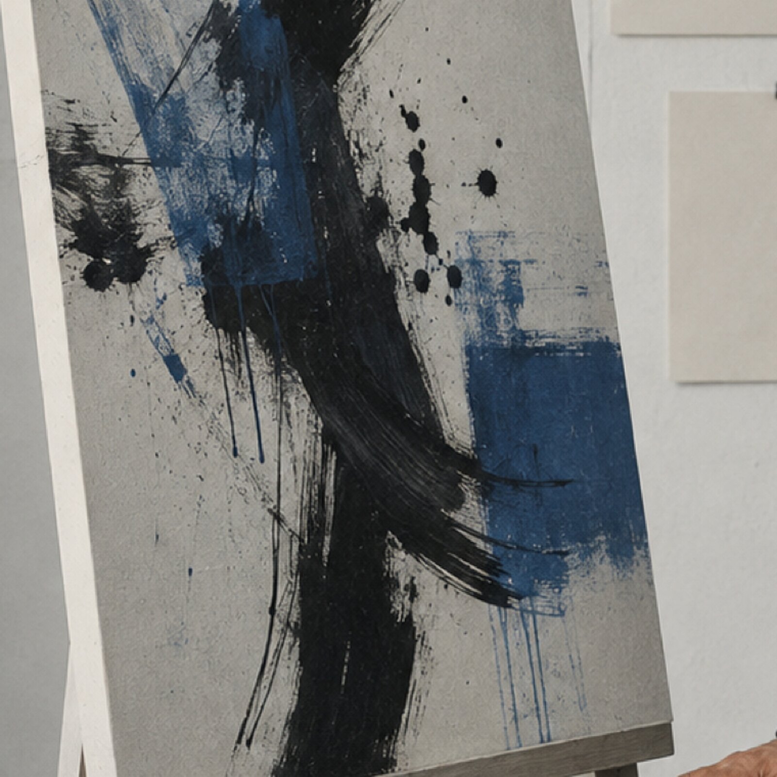 Abstract panel of black ink and cobalt brush strokes on a pale canvas.
